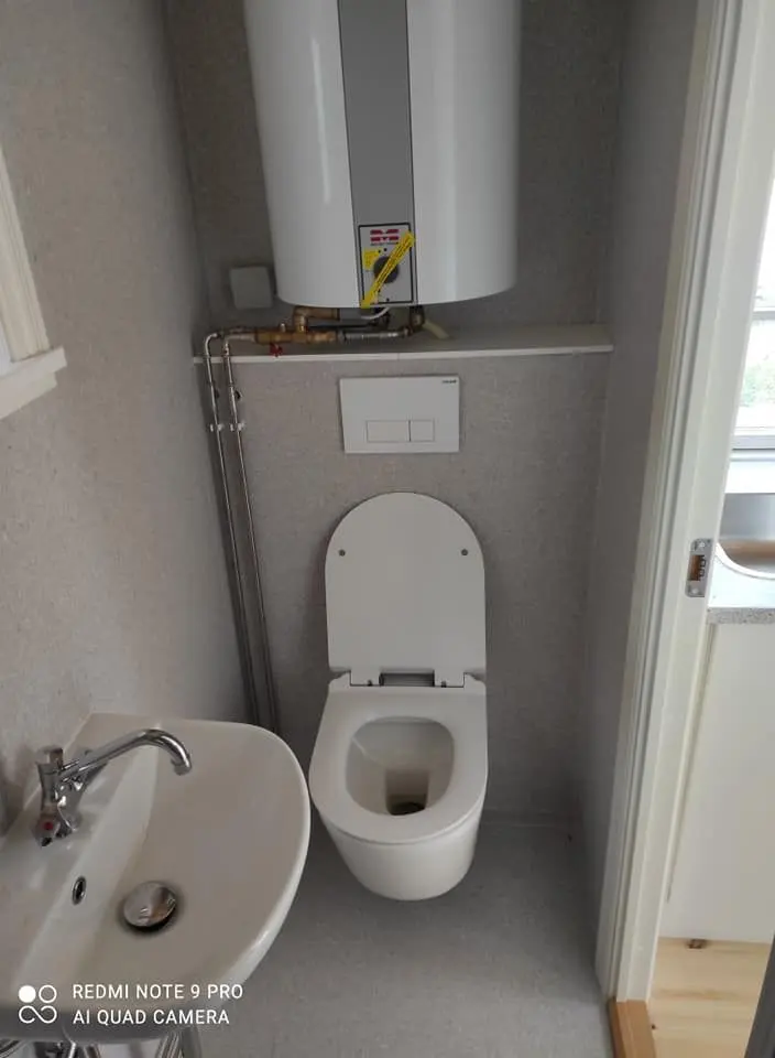 Badeværelse i Ditlev med væghængt toilet og håndvask